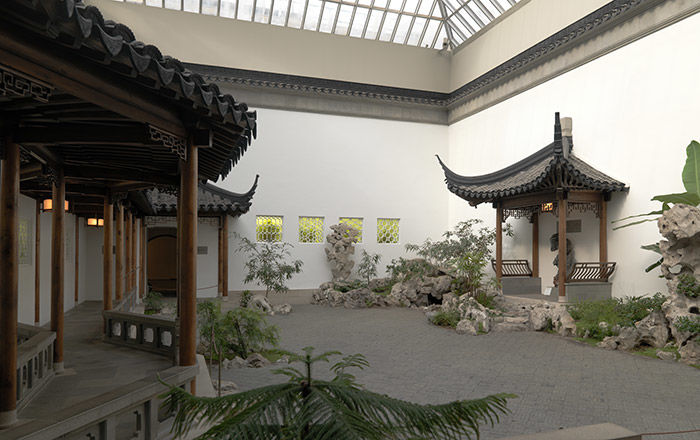 An interior courtyard with pagodas, plantings, ornamental rocks, and a fish pond