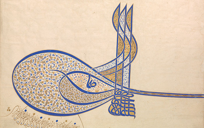 A highly ornate calligraphic Arabic signature in blue and decorated profusely with tiny painted and gilded flowers in blue and white